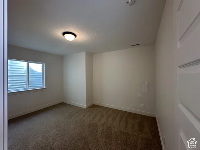 Carpeted room with a double-paned window, white trim, and a semi-flush mount ceiling light