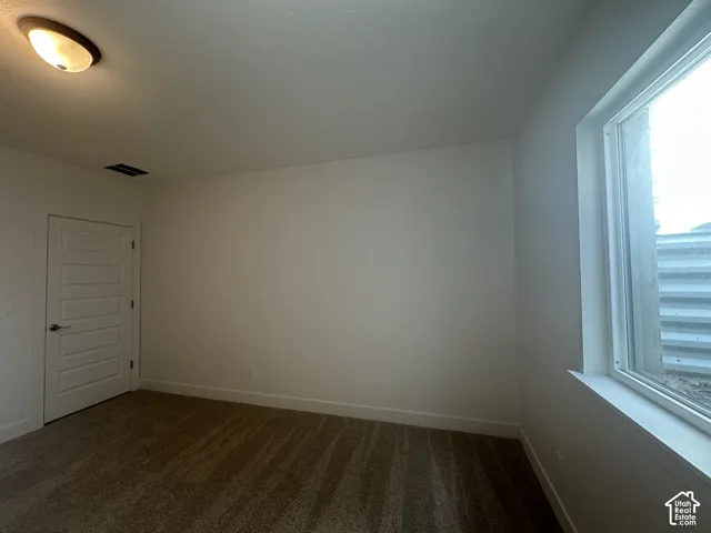 Neutral wall finishes with a window, modern five-panel interior door, and ceiling light fixture