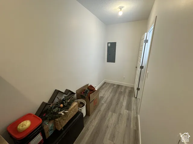 Hallway featuring neutral wall paint, wood-finish flooring, and a contemporary flush-mount ceiling light