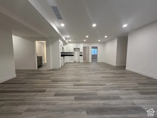 Open-concept living space featuring wood-finish flooring, recessed lighting, and white walls