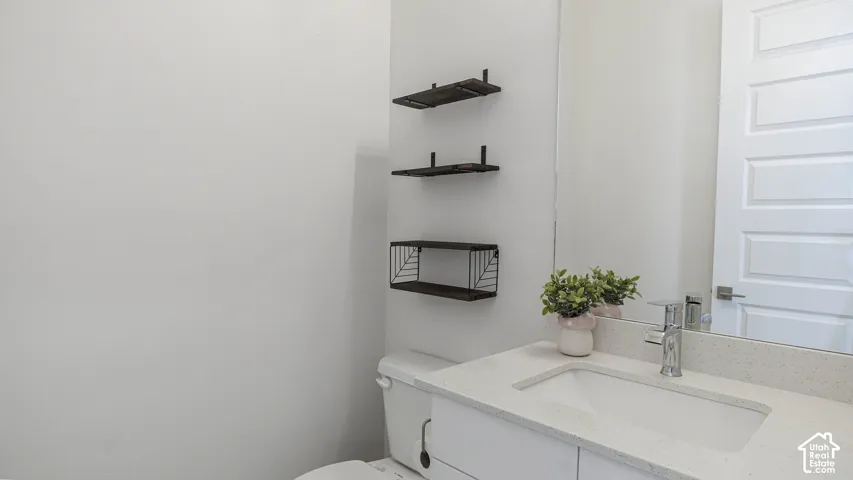 White vanity with an integrated sink, light-toned countertop, and chrome faucet