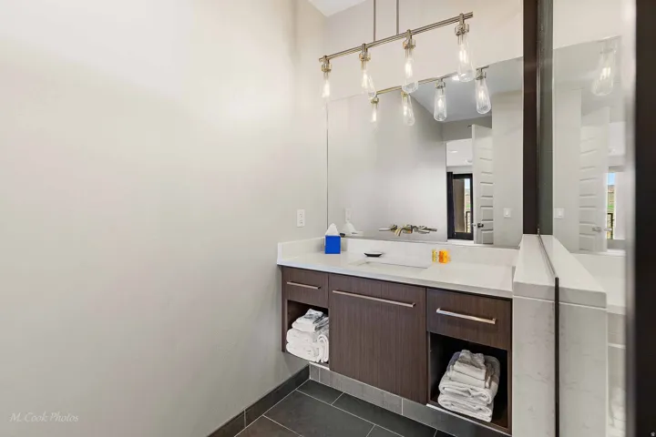 Modern vanity featuring a wall-mounted faucet, an integrated rectangular sink, and a light-colored countertop