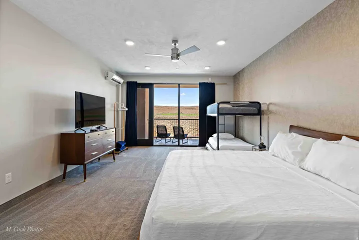 Spacious room featuring carpeting, recessed lighting, ceiling fan, split air conditioning unit, and private balcony access