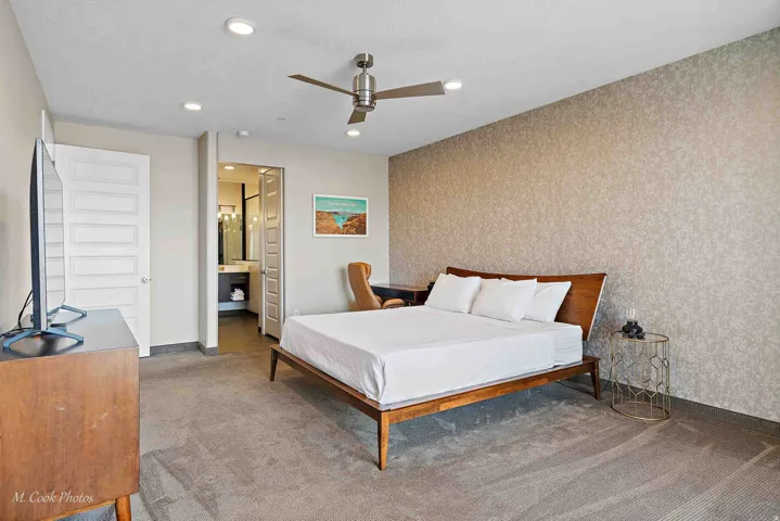 Spacious room featuring patterned accent wall, recessed lighting, ceiling fan, and carpeted flooring
