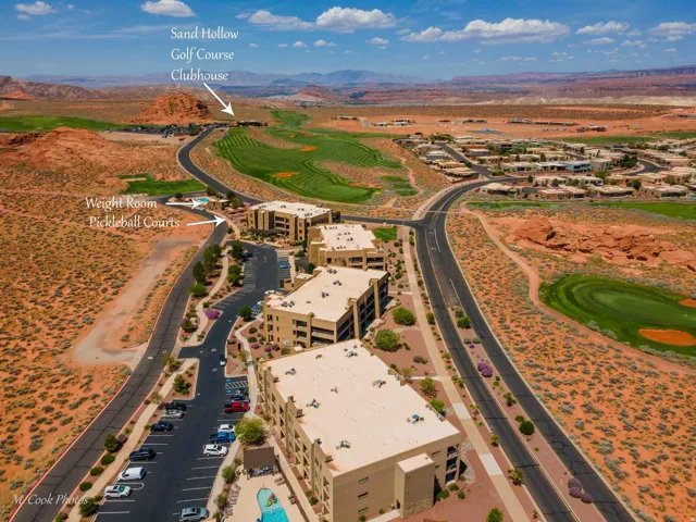 Striking desert property featuring a contemporary multi-story residence with tan stucco exterior, situated on expansive grounds with manicured fairway-style landscaping