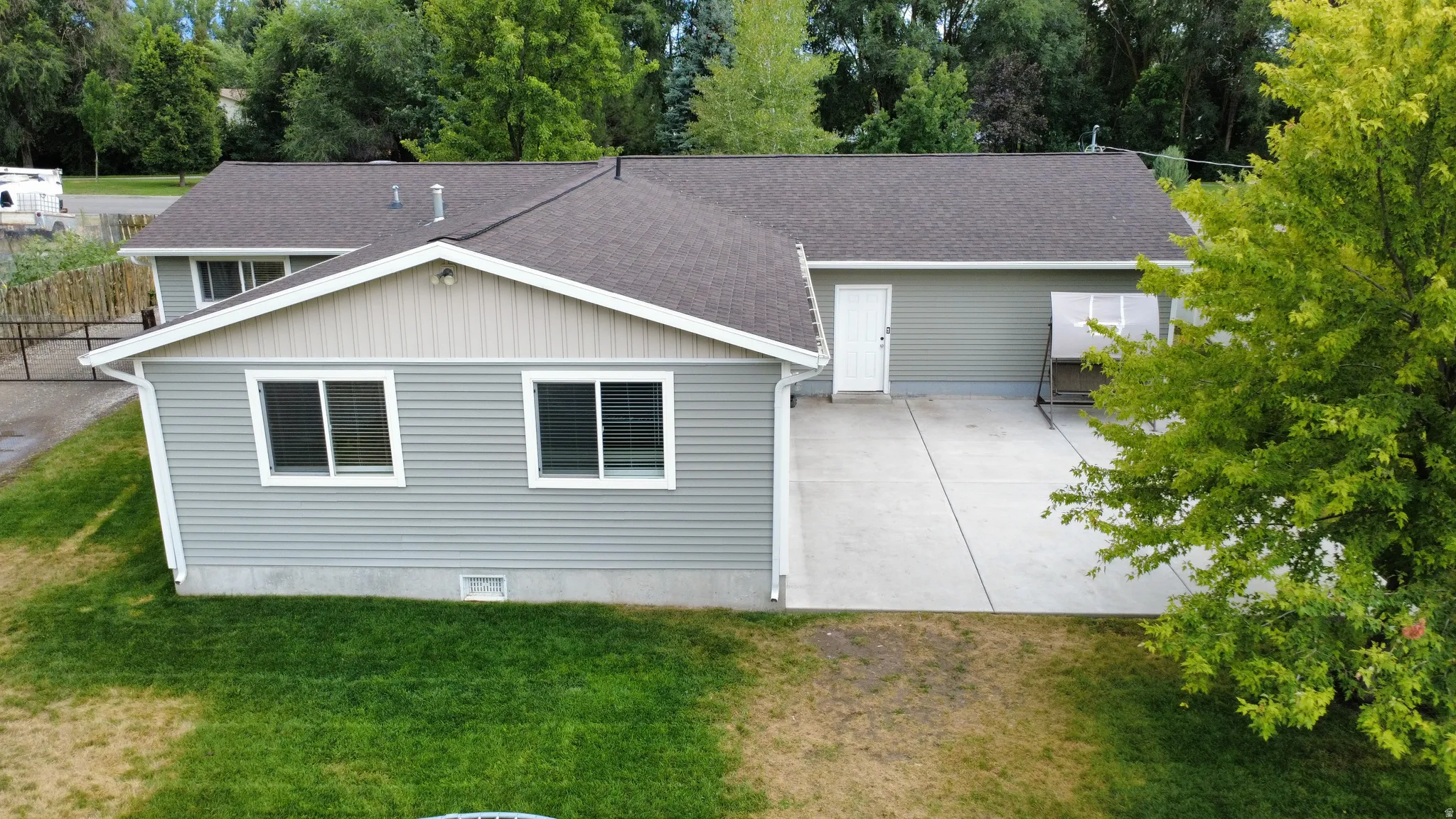 Light gray siding exterior with a dark shingle roof