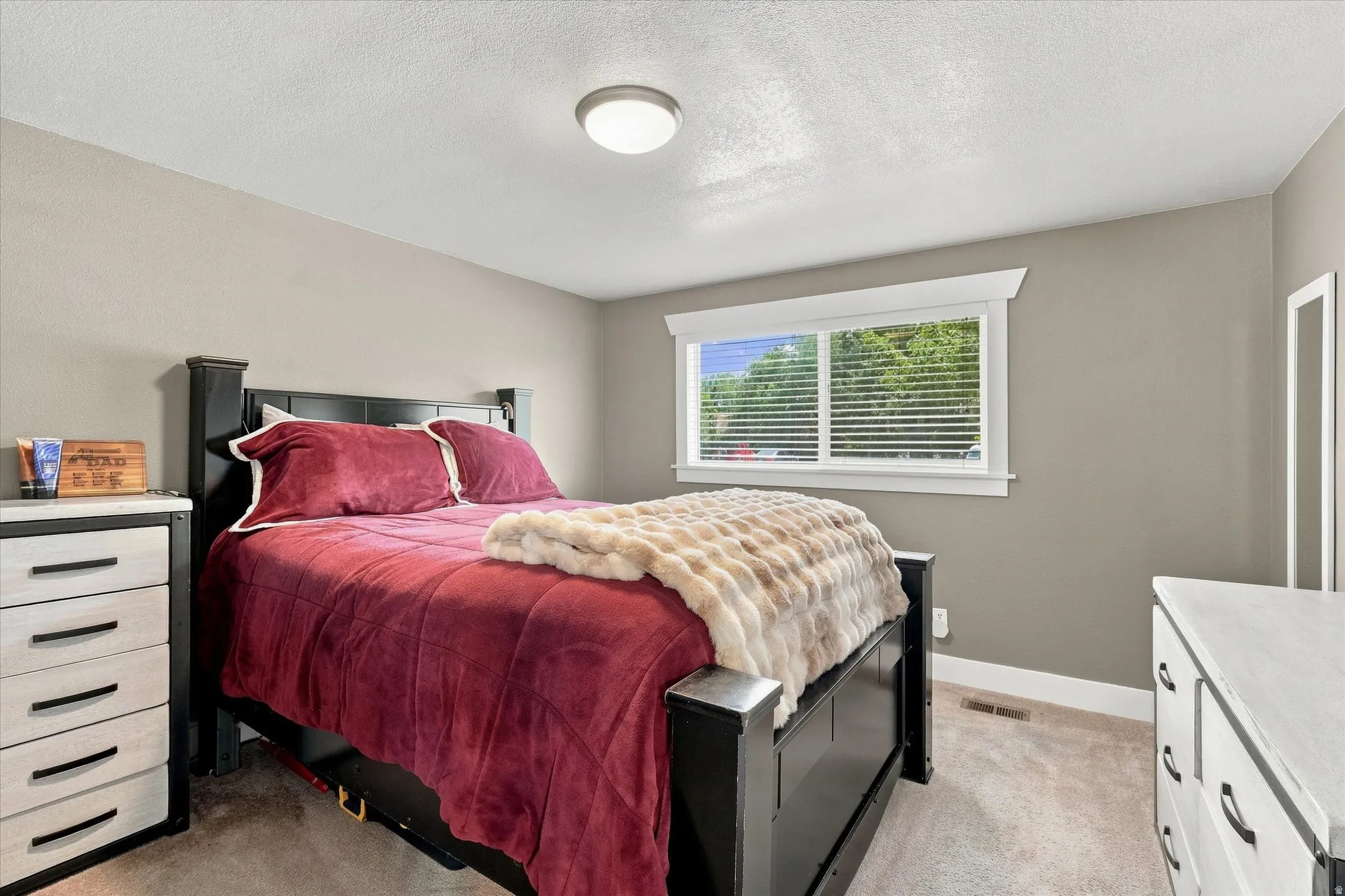 Bedroom featuring neutral-toned walls, white trim, and carpet flooring