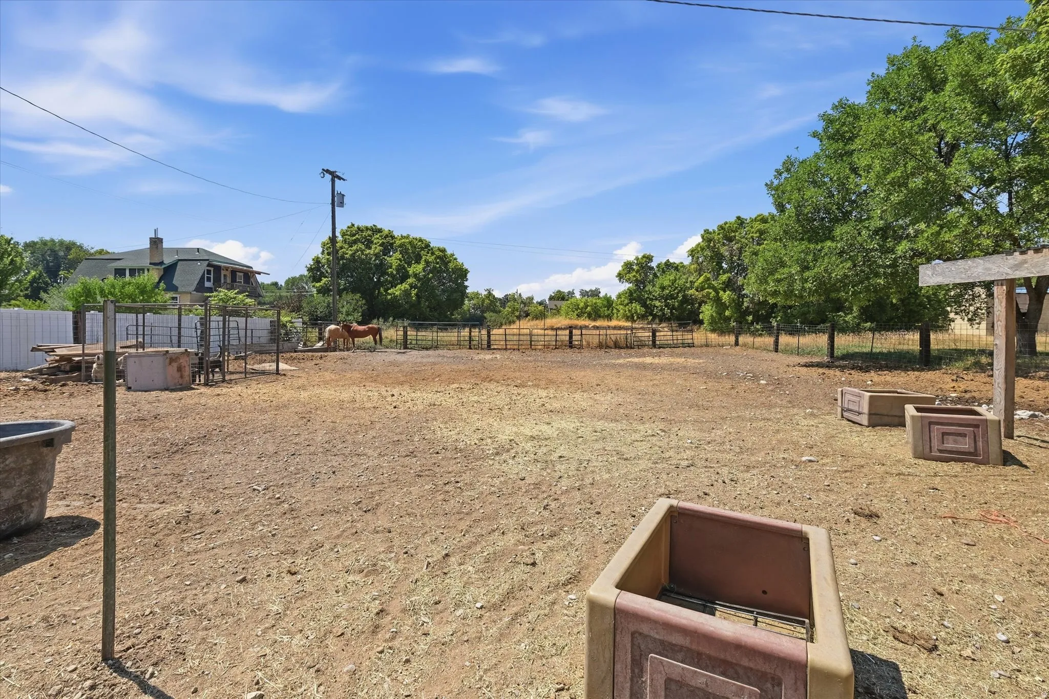 Expansive outdoor area featuring a combination of fenced enclosures and open ground