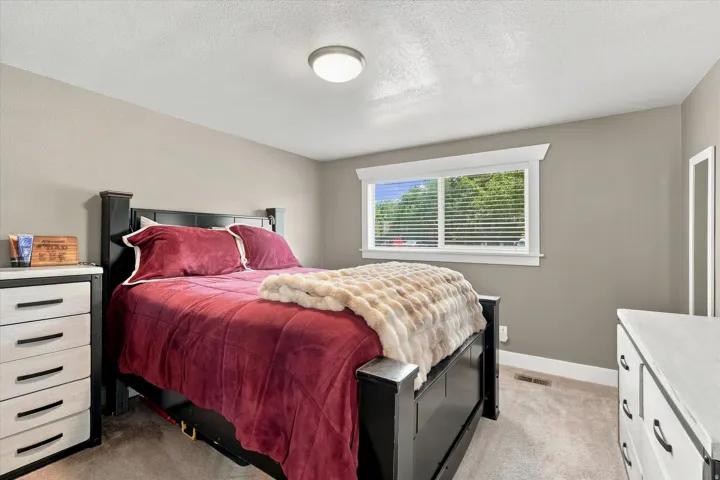 Bedroom featuring neutral-toned walls, white trim, and carpet flooring