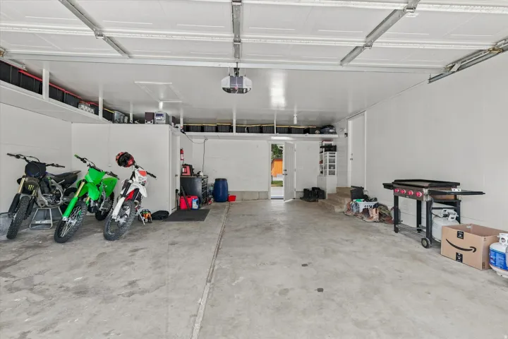 Expansive garage featuring a concrete floor, white walls, and a white paneled garage door