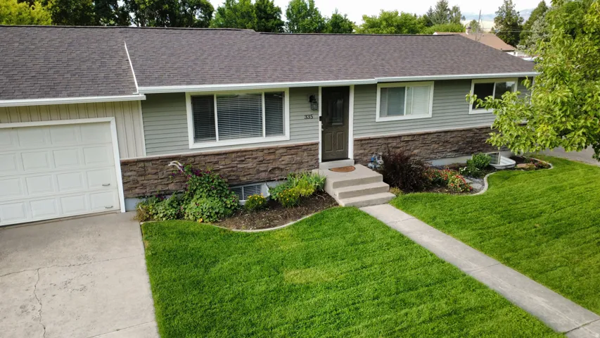 Siding exterior with stone veneer accents, asphalt shingle roofing, and a concrete driveway
