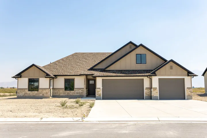 Contemporary exterior with stone accent, board and batten siding, and a two-car garage