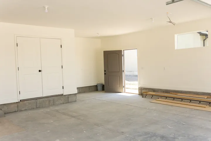 Spacious garage with concrete flooring, white painted walls, and a window for natural light