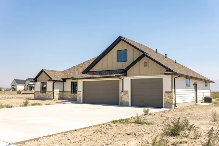 Contemporary exterior with stone veneer accents, light-colored siding, and a dark shingle roof