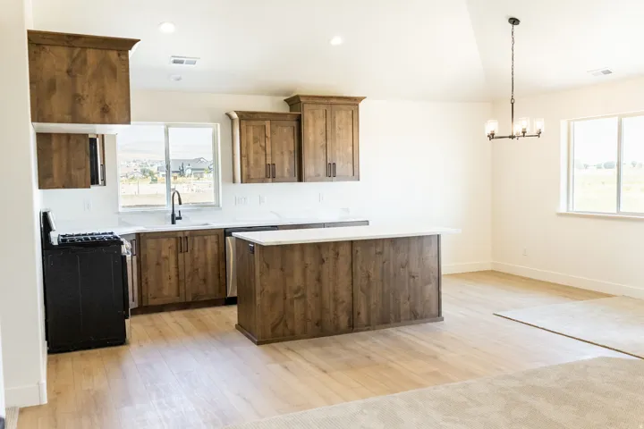 Kitchen featuring wood-finish cabinetry, white countertops, and a black gas range