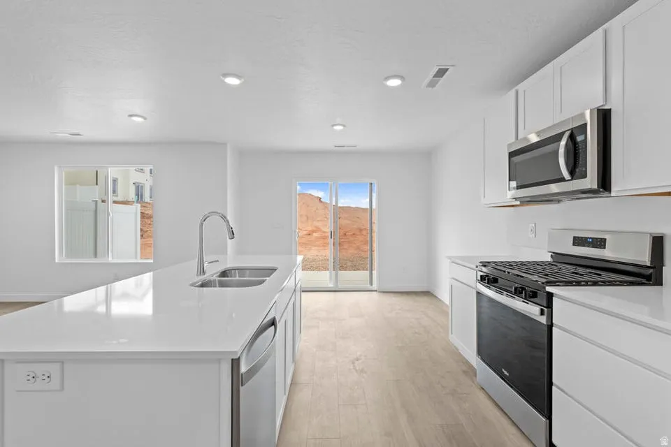 Modern kitchen featuring a large island with a double basin sink and gooseneck faucet