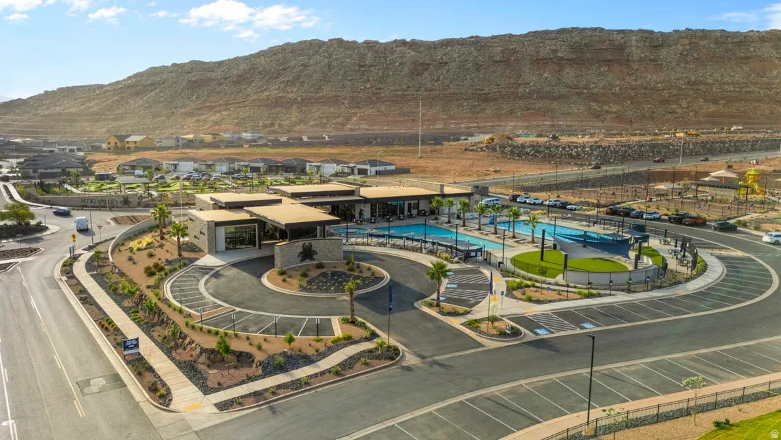 Community clubhouse featuring multiple pools, structured landscaping, and a central roundabout entrance