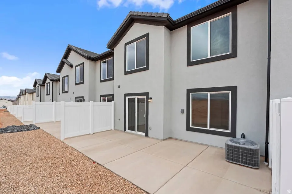 Private fenced patio area featuring a concrete slab, sliding glass door access, and a gravel perimeter
