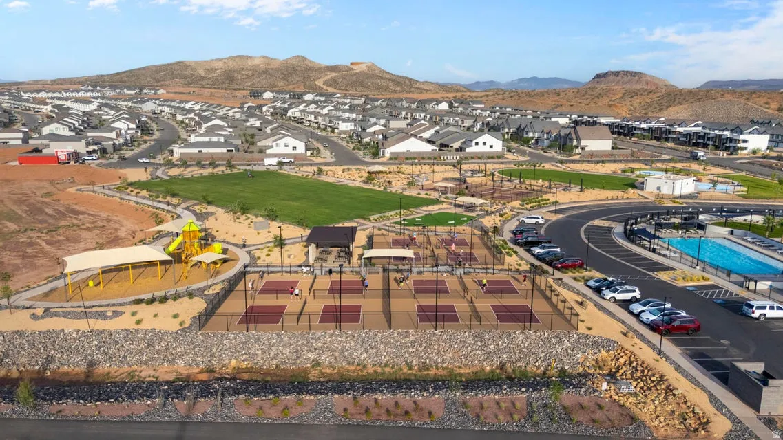 Community recreational area featuring multiple pickleball courts, a playground with shade structures, a large green space, and a swimming pool