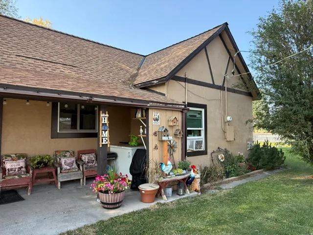 Exterior featuring a covered patio, stucco siding, dark trim accents, and a shingled roof