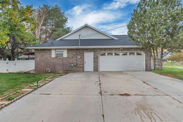 Brick exterior with a two-car garage featuring decorative window inserts, an additional entry door, and a concrete driveway