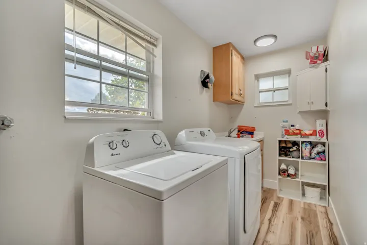 Utility room featuring wood-finish flooring, two windows, and built-in cabinetry