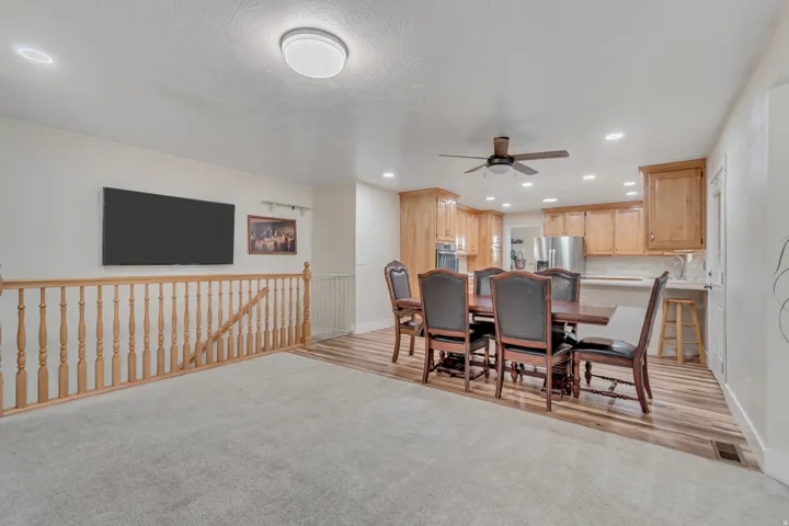 Open-concept living space featuring light wood-finish flooring, a contemporary ceiling fan, and recessed lighting