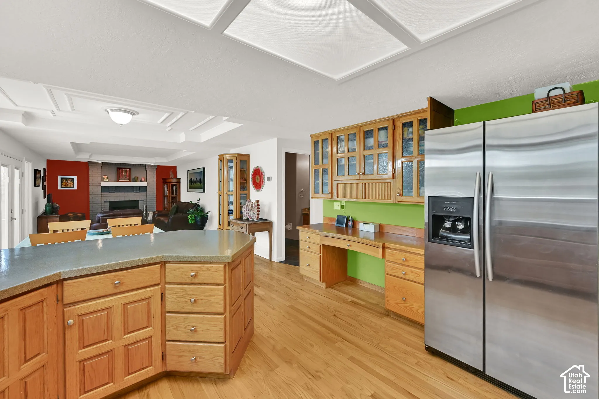 Kitchen featuring a stainless steel side-by-side refrigerator, extensive wood cabinetry, and a built-in desk area