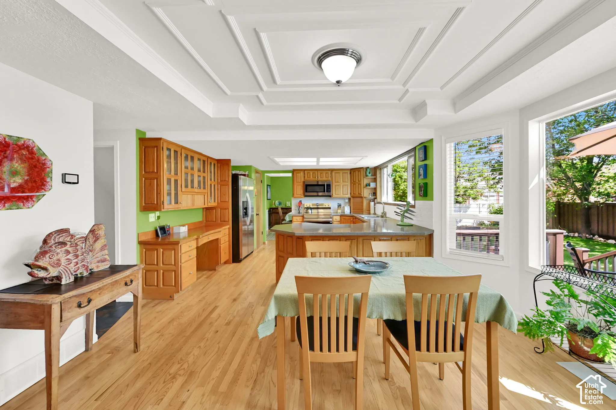 Coffered ceilings accent this expansive kitchen and dining area featuring wood flooring