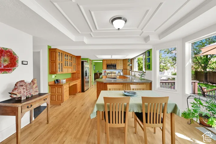 Coffered ceilings accent this expansive kitchen and dining area featuring wood flooring