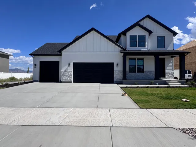 Modern farmhouse exterior with white siding, dark trim, and a covered porch entry
