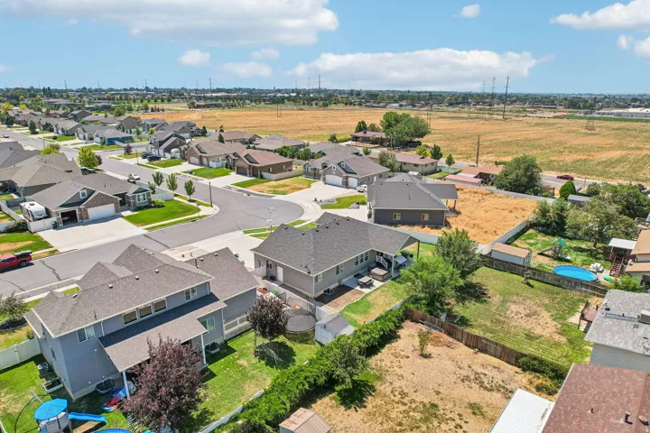 Aerial view of this contemporary home situated on expansive grounds featuring manicured landscaping, mature trees, and a resort-style backyard with in-ground pool