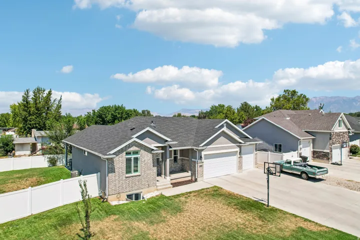 Elegant brick ranch home featuring a gabled roofline with architectural detail, expansive driveway with RV parking capability, and professionally landscaped front grounds
