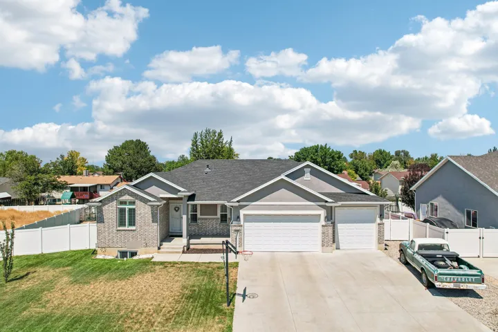 Charming ranch-style home featuring a striking gabled roofline, dual two-car garage with white panel doors, and a spacious concrete driveway