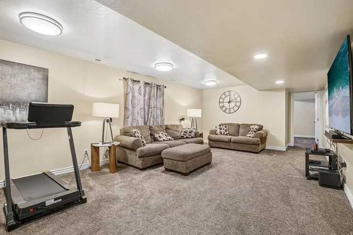 Spacious recreation room featuring recessed lighting, a neutral color palette, and durable carpeting