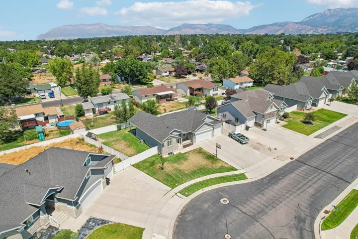 Aerial view of a newly constructed residential community featuring modern single-family homes with contemporary architectural styling, dark asphalt roofing, and light-colored exterior finishes