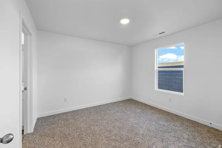 Neutral white walls with a single window and recessed lighting