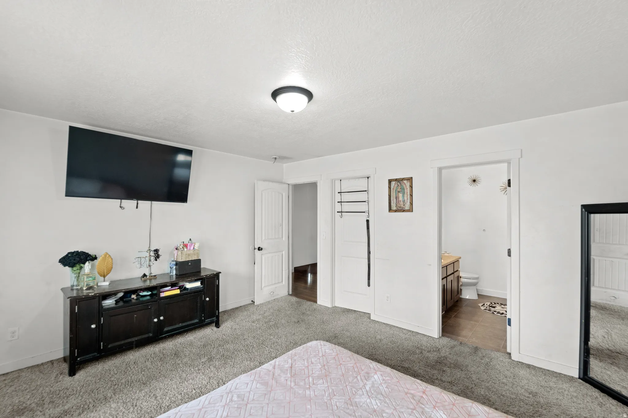 Carpeted interior with light-toned walls and a flush-mount ceiling light