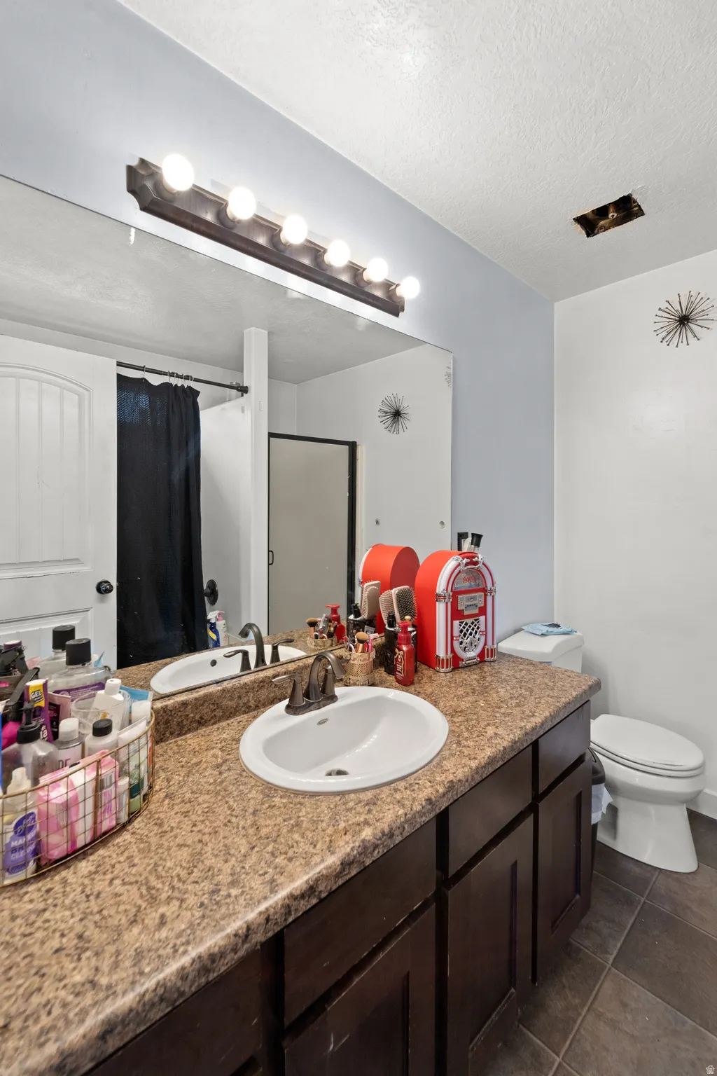 Bathroom vanity featuring an integrated sink, a speckled countertop, and dark wood-finish cabinetry