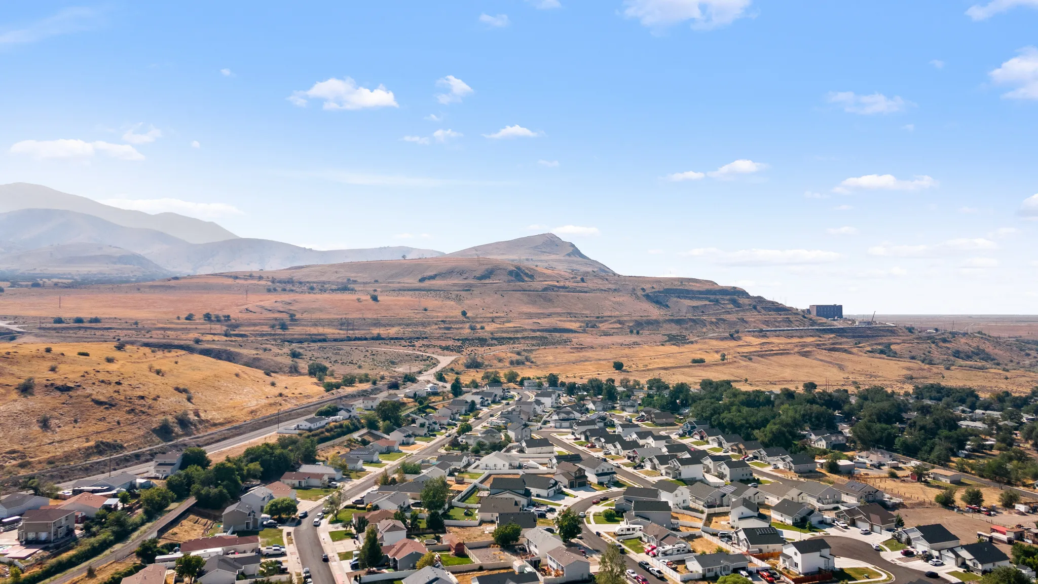Aerial perspective showcasing a residential community nestled against a backdrop of distant mountains