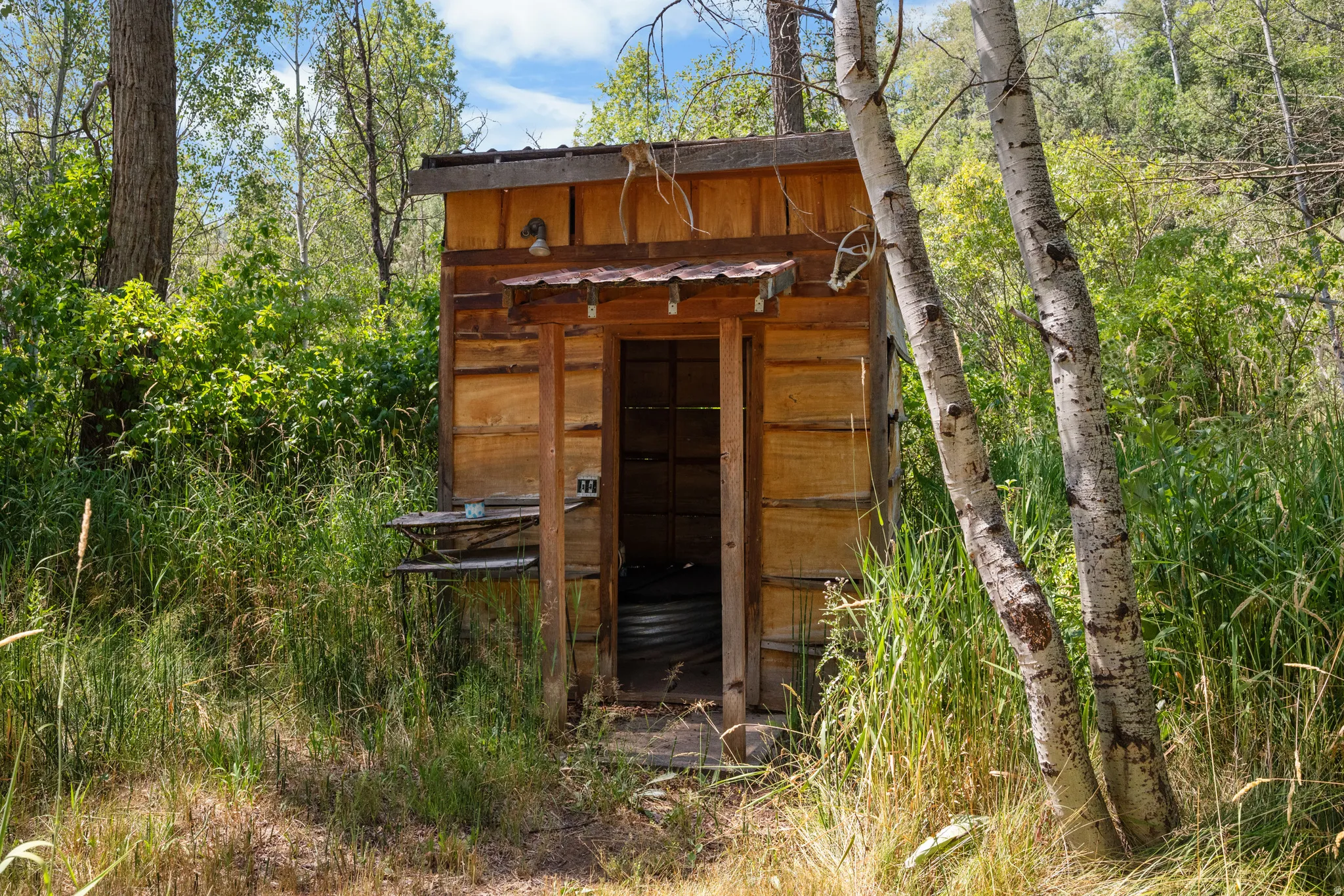 Rustic wood-sided outbuilding with a metal roof accent