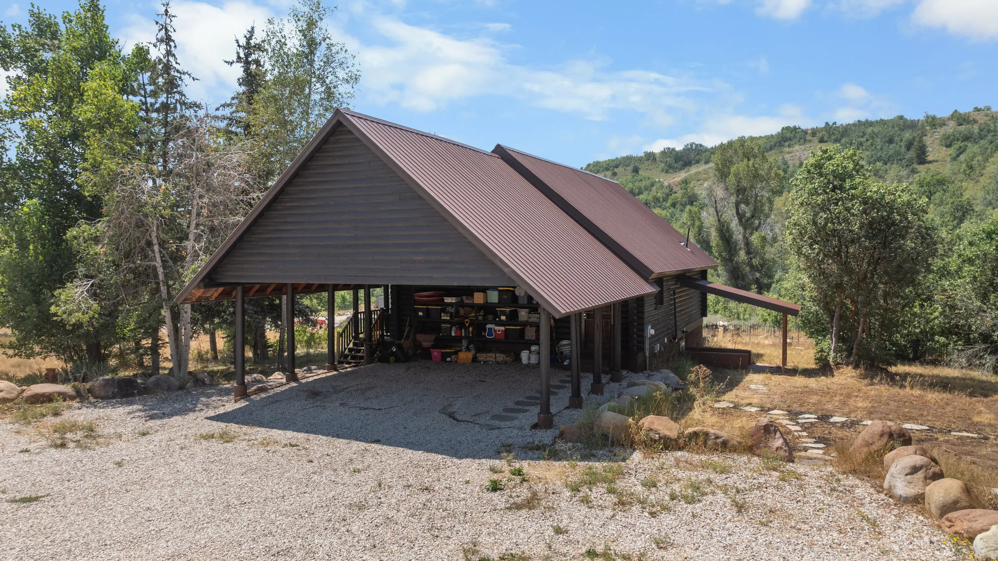 Expansive outbuilding featuring a corrugated metal roof and a deep carport
