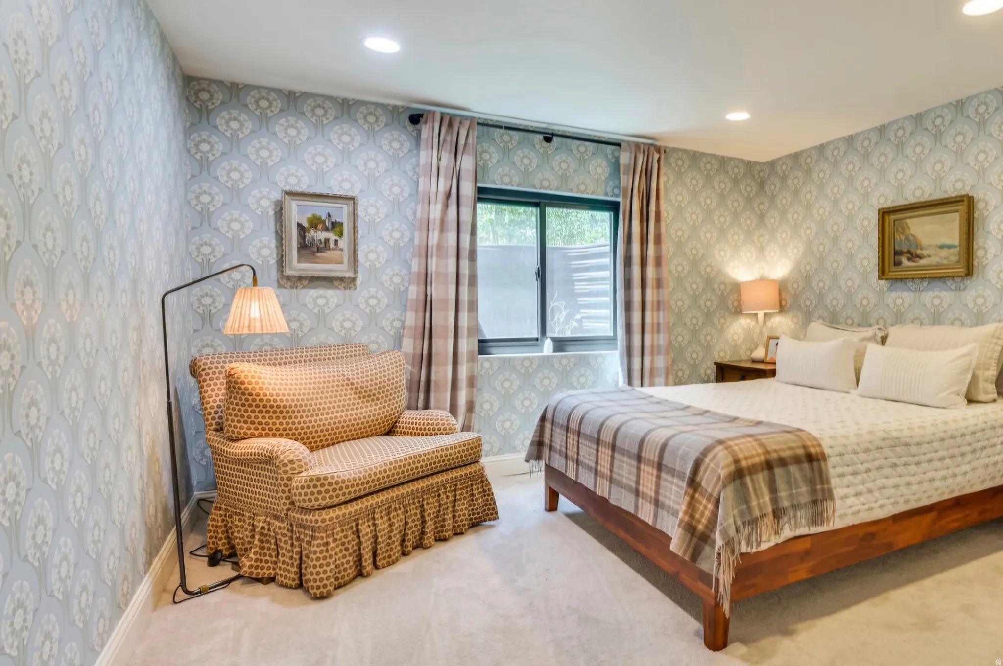 Bedroom featuring patterned wallpaper, recessed lighting, and a window with privacy blinds