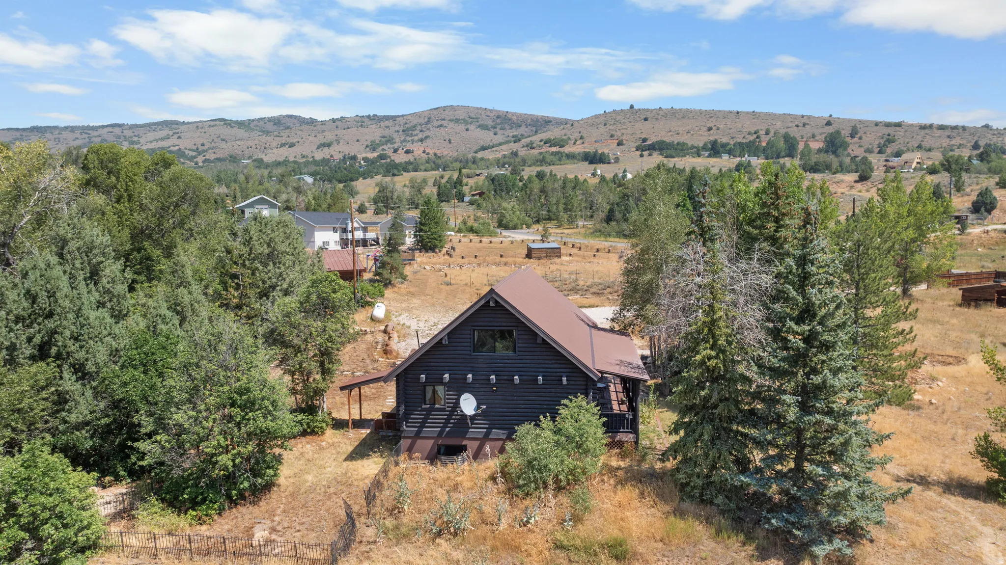Multi-level residence featuring dark siding and a brown roof