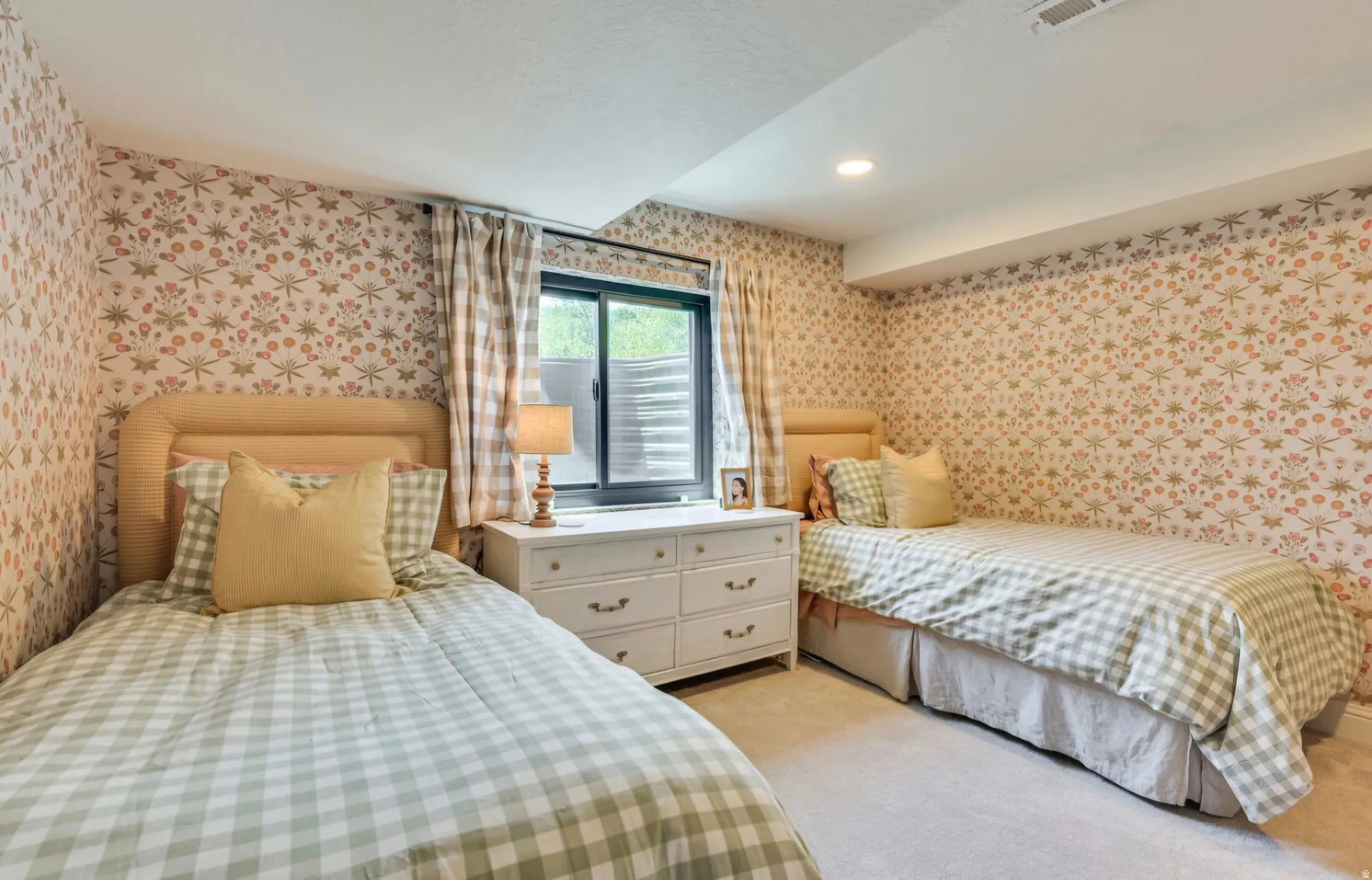 Bedroom featuring patterned wallpaper, carpeted flooring, and a recessed ceiling light