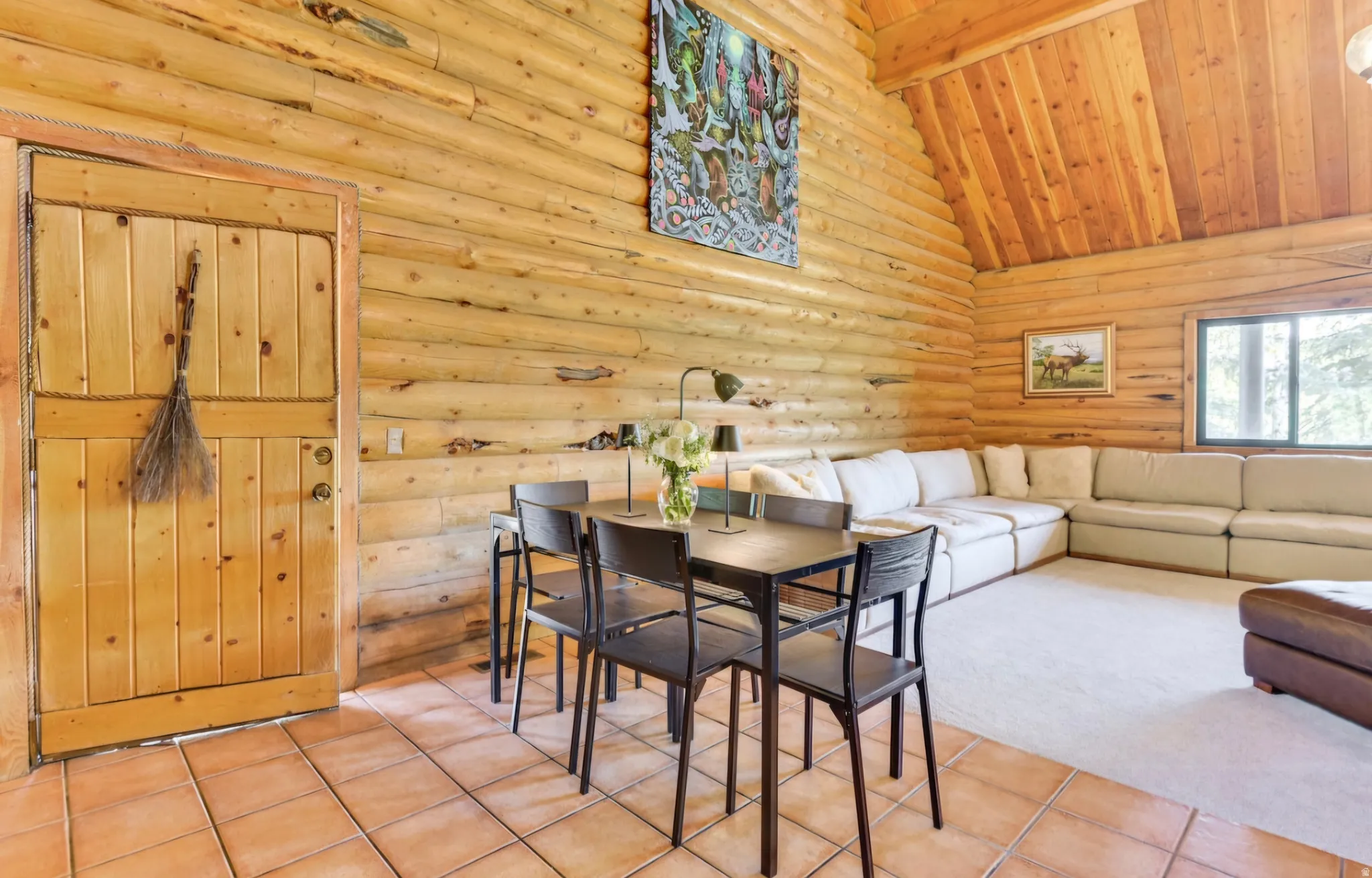 Log cabin interior featuring robust log walls and a vaulted wood-plank ceiling