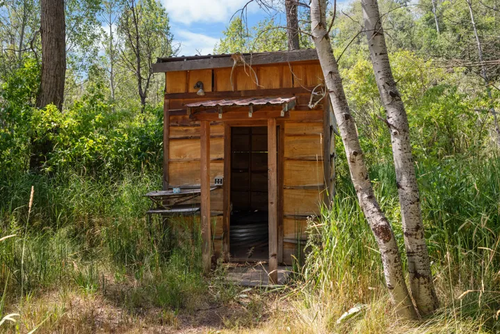 Rustic wood-sided outbuilding with a metal roof accent