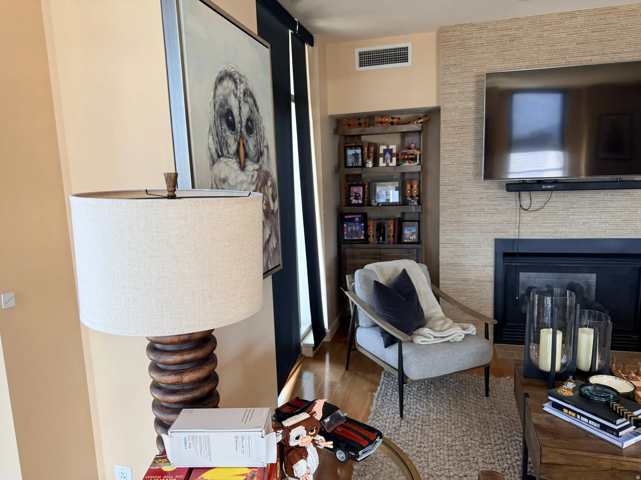 Sophisticated living room showcasing hardwood flooring, a wood-burning fireplace with dark surround, and exposed brick accent wall