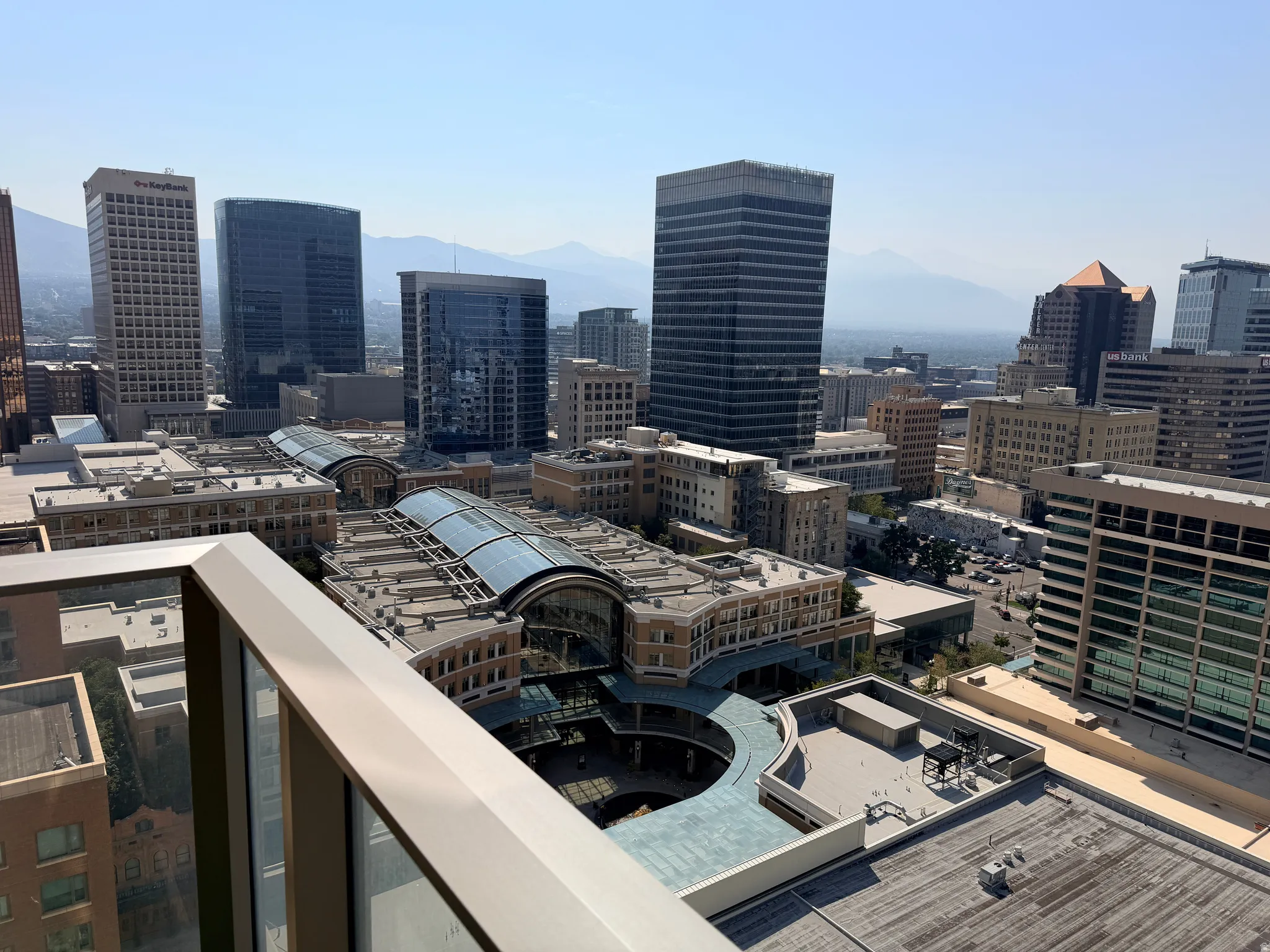Expansive city skyline with distant mountains, featuring multiple high-rise buildings and modern architectural structures