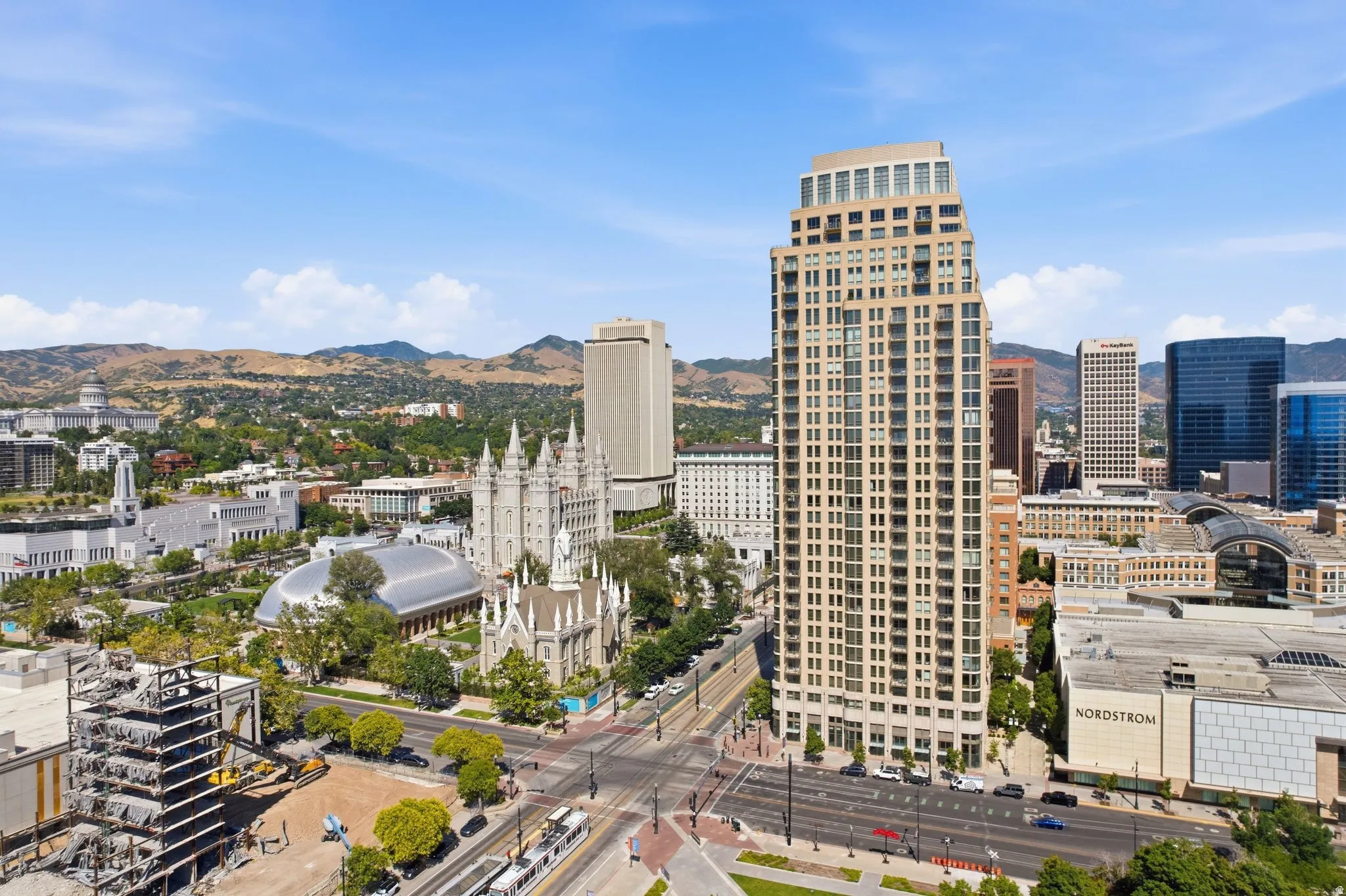 Elevated city panorama featuring a prominent high-rise building with multiple balconies